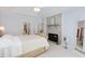 Comfortable main bedroom featuring a decorative fireplace, tray ceilings, and furniture at 220 Autumn Sage Dr, Alpharetta, GA 30005