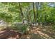 Private backyard featuring mature trees, a small garden, and outdoor seating area at 3051 Deanna Way, Lawrenceville, GA 30044