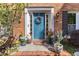 Inviting blue front door with a wreath, potted plants, and brick accents at 3051 Deanna Way, Lawrenceville, GA 30044