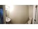 Well-lit half bathroom with a pedestal sink, white toilet, and a large mirror, offering functionality at 3336 Waldrop Trl, Decatur, GA 30034