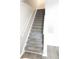 Carpeted staircase with white railing leading to the upper level of this home at 3336 Waldrop Trl, Decatur, GA 30034