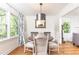 Bright dining room with stylish lighting, hardwood floors, and views of the landscaped outdoors at 4175 Valley Trail Se Dr, Atlanta, GA 30339