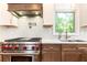 Modern kitchen featuring stainless steel appliances, tile backsplash, custom cabinetry, and a view to the yard at 4175 Valley Trail Se Dr, Atlanta, GA 30339