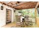 Outdoor porch with stainless grill, wooden rocking chairs, and brick exterior with hanging string lights at 4175 Valley Trail Se Dr, Atlanta, GA 30339