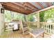 Inviting outdoor porch with wooden rocking chairs, grill and bench for outdoor entertaining at 4175 Valley Trail Se Dr, Atlanta, GA 30339