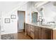 Bright bathroom with a double sink vanity, granite counters, wooden cabinets and silver framed mirrors at 2029 Tuxedo Ne Ave, Atlanta, GA 30307