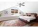 Bedroom features a slanted ceiling, ceiling fan, natural light, and decorative rug at 2029 Tuxedo Ne Ave, Atlanta, GA 30307