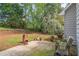 Backyard with patio, seating area, and grassy lawn with mature landscaping, ideal for outdoor living at 2602 White Aster Ln, Dacula, GA 30019