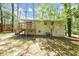Home's backyard featuring a wooden deck that is nestled amongst trees and a grassy lawn at 2650 Gwendon Ct, Decatur, GA 30034