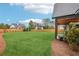 Large grassy backyard with wood fence and partial view of covered patio with wooden support beams at 1095 Lanier Pl, Cumming, GA 30041