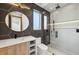 Modern bathroom featuring a black hexagon tiled wall, walk-in shower and a round mirror at 1095 Lanier Pl, Cumming, GA 30041
