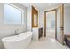 Bright bathroom with a soaking tub and modern light wood accents at 1095 Lanier Pl, Cumming, GA 30041