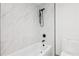 Clean bathroom with white marble-style tile, soaking tub, and black fixtures at 1095 Lanier Pl, Cumming, GA 30041