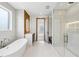 Bright bathroom featuring a soaking tub and walk in shower with white tile flooring at 1095 Lanier Pl, Cumming, GA 30041