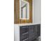 Stylish bathroom vanity with a marble countertop, dark wood cabinets, and a decorative illuminated mirror at 1095 Lanier Pl, Cumming, GA 30041