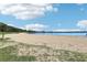 Expansive beach view with soft sand meeting calm waters under a bright sky with scattered clouds, creating a serene atmosphere at 1095 Lanier Pl, Cumming, GA 30041