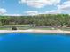 Expansive beach view with fine sand, clear blue water, parking and trees along the shoreline at 1095 Lanier Pl, Cumming, GA 30041