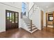 Elegant foyer with hardwood floors, a modern staircase, and a glimpse into a stylish bathroom at 1095 Lanier Pl, Cumming, GA 30041