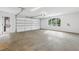 Spacious two-car garage with sealed concrete floor, bright lighting, and access door to exterior at 1095 Lanier Pl, Cumming, GA 30041
