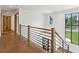 Second floor hallway with hardwood floors, and modern railings leading to rooms with exterior views at 1095 Lanier Pl, Cumming, GA 30041