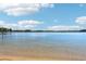 Scenic lake view with clear water, a sandy beach, and a serene horizon under a blue sky with light clouds at 1095 Lanier Pl, Cumming, GA 30041