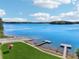 Beautiful lake view featuring multiple docks and a boat ramp surrounded by lush green grass and blue sky with light cloud cover at 1095 Lanier Pl, Cumming, GA 30041