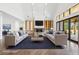 Staged living room with modern sofas, a stone fireplace, and folding glass doors to the backyard at 1095 Lanier Pl, Cumming, GA 30041
