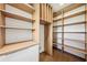 Custom walk-in pantry features wood shelving, white cabinets and dark wood floors at 1095 Lanier Pl, Cumming, GA 30041