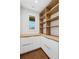 Butlers pantry with white shaker cabinets, wood counters, and open wooden shelves at 1095 Lanier Pl, Cumming, GA 30041