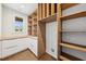 Custom walk-in pantry features wood shelving, white cabinets and a view to the exterior at 1095 Lanier Pl, Cumming, GA 30041