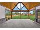 Covered patio featuring vaulted wood ceiling, black beams, and backyard view of the lawn and fence at 1095 Lanier Pl, Cumming, GA 30041