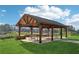 A spacious wooden pavilion with picnic tables offering a shady gathering spot within a serene outdoor setting at 1095 Lanier Pl, Cumming, GA 30041