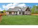 Rear view of the home showcasing the expansive backyard and covered patio, blending indoor/outdoor living with modern design at 1095 Lanier Pl, Cumming, GA 30041