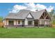 Back of home featuring a covered patio, brick accents, and a spacious green lawn, perfect for outdoor living and entertainment at 1095 Lanier Pl, Cumming, GA 30041