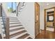 Elegant staircase with hardwood treads, sleek metal railings, and a view of a stylish powder room at 1095 Lanier Pl, Cumming, GA 30041