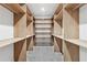 Spacious walk-in closet with custom built-in wood shelving and carpet flooring at 1095 Lanier Pl, Cumming, GA 30041