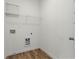 Clean laundry room features a white interior, wooden floor, metal shelving and utility hookups at 136 Grant Dr, Canton, GA 30114