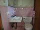 Bathroom features pink tiling, a vintage sink, and toilet at 1888 Delphine Dr, Decatur, GA 30032