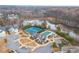 Beautiful aerial view of a community clubhouse, pool, and tennis courts by a lake surrounded by colorful trees at 3945 Starwood Dr, Cumming, GA 30028