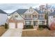 Charming two-story brick home featuring a manicured lawn, two-car garage, and welcoming front porch at 3945 Starwood Dr, Cumming, GA 30028