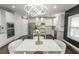 Eat-in kitchen with white cabinets, stainless steel appliances, granite countertops, and modern lighting at 3945 Starwood Dr, Cumming, GA 30028