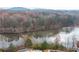 Scenic aerial view of a lake surrounded by lush trees near a community pool with lounge chairs at 3945 Starwood Dr, Cumming, GA 30028
