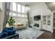 Grand living room featuring soaring ceilings, large windows, fireplace, and comfortable seating, ideal for relaxation at 3945 Starwood Dr, Cumming, GA 30028