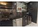 Wet bar featuring black honeycomb tile backsplash, floating glass shelves, a wine cooler, and stainless steel appliances at 3945 Starwood Dr, Cumming, GA 30028