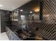 Stylish wet bar featuring black honeycomb tile backsplash, open shelving, modern faucet, and a mounted TV at 3945 Starwood Dr, Cumming, GA 30028