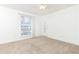 This bedroom features a neutral carpet, a window with blinds, and a door for access at 5672 Kingsport Dr # 4, Atlanta, GA 30342