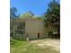 Side of home showing a garage, door, porch, and forested backyard at 1905 Rockmart Rd, Villa Rica, GA 30180