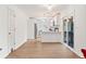 Open layout with white walls, light hardwood floors, and a modern kitchen leading to dining area at 160 Fieldstone Dr, Powder Springs, GA 30127