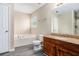 Bright bathroom featuring a soaking tub, wooden vanity with granite countertop, and a large mirror at 175 Regency Park Dr, Mcdonough, GA 30253