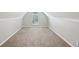Finished attic with carpeted flooring, fresh paint, and a bright arched window at 1945 Grayson Oaks Ct, Lawrenceville, GA 30045